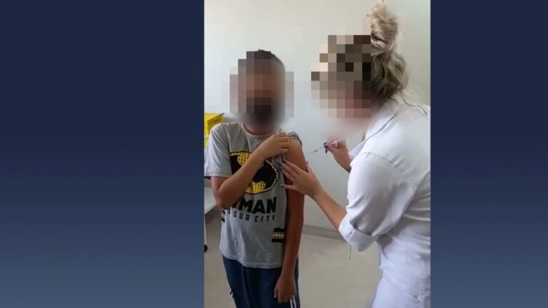 Depois de falsa vacinação, criança é vacinada em Taubaté. Pelas imagens feitas pela mãe da criança no ato da vacinação, enfermeira coloca agulha no braço de criança, mas não a vacina em Taubaté.